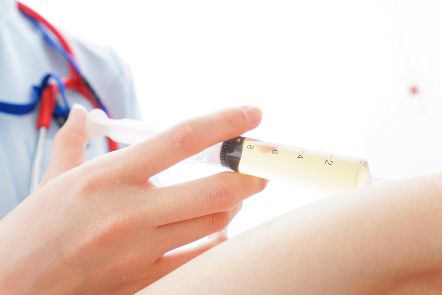 A photo of a doctor injecting Protein-Rich Growth Product into a patient's elbow